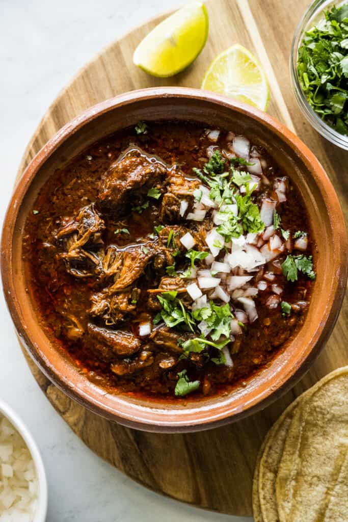 Birria in a bowl with cilantro and diced white onions