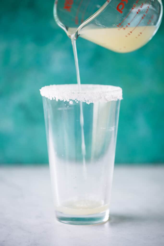 Lime juice being poured in a pint glass