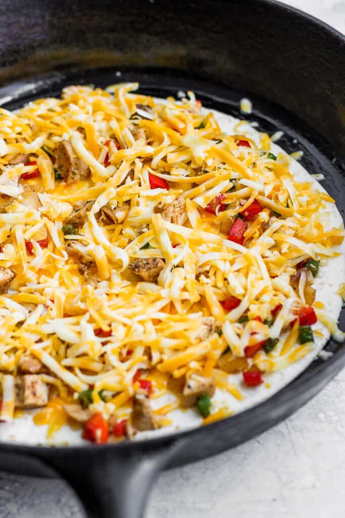 A chicken quesadilla cooking in a skillet.