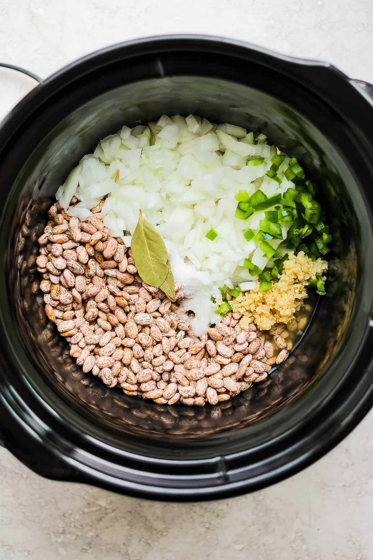 Ingredients for crock pot pinto beans in a slow cooker.