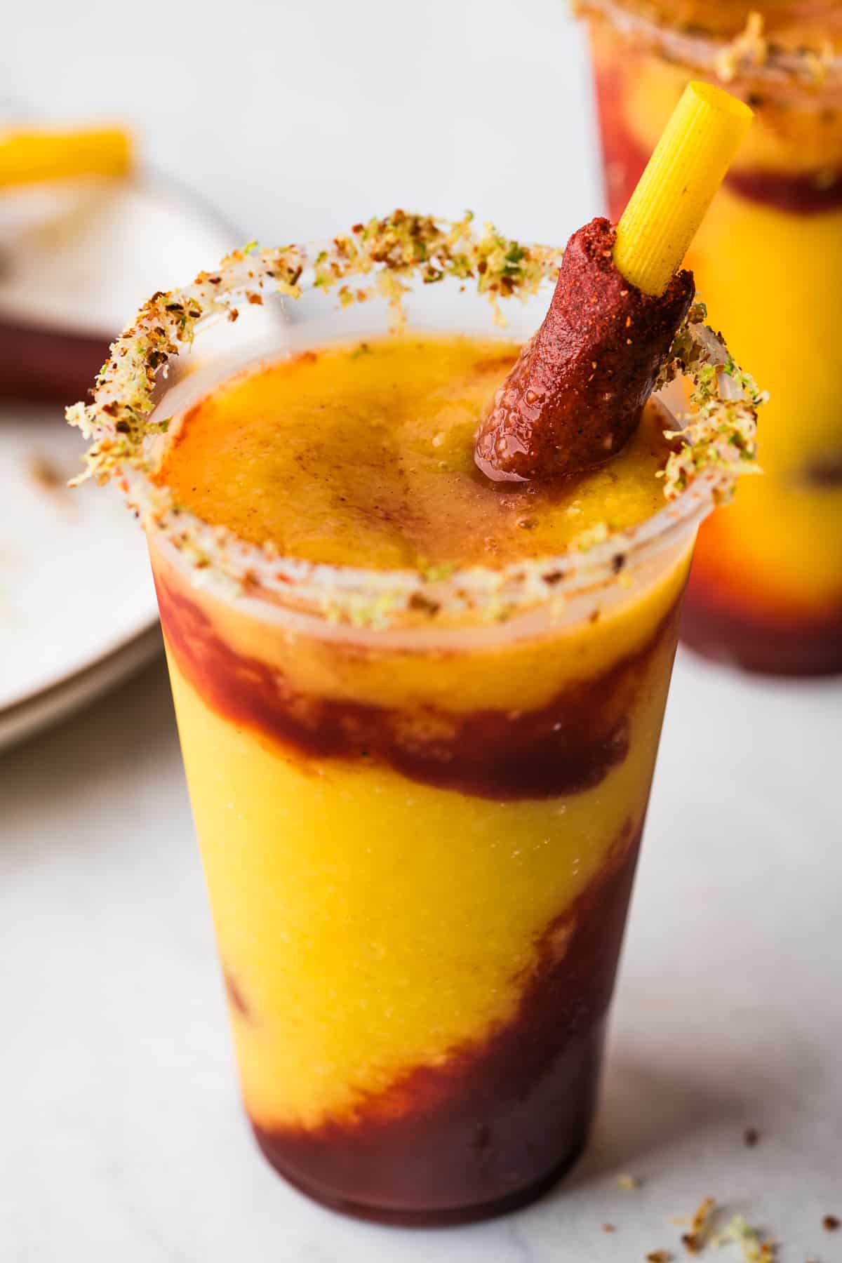 A mangonada made with blended mango mixed with chamoy in a rimmed lime and tajin glass.