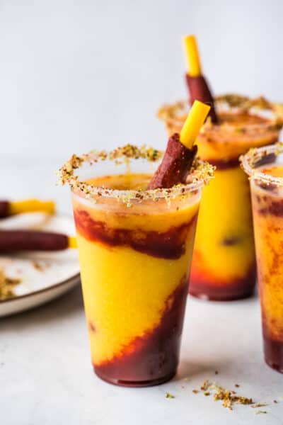 Mangonadas in clear plastic cups with a tamarind candy straws.