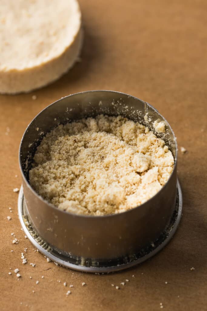 Ground mazapan mixture in a round cookie mold.