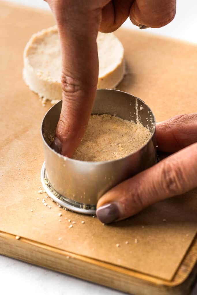 A finger pressing the mazapan mixture in a cookie mold to it can compact and hold its shape.
