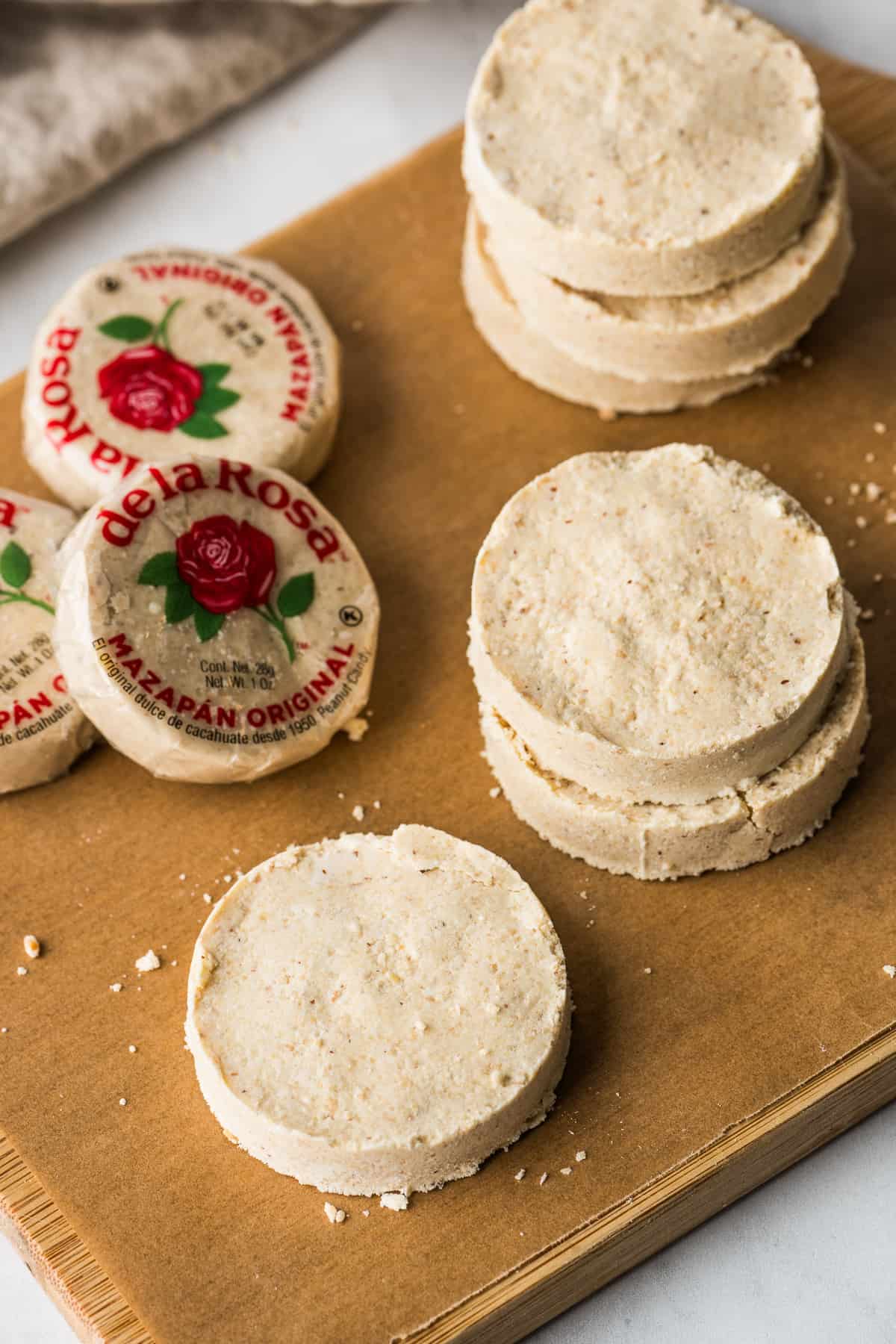 Homemade mazapan on a cutting board next to store-bought de la rosa mazapan.