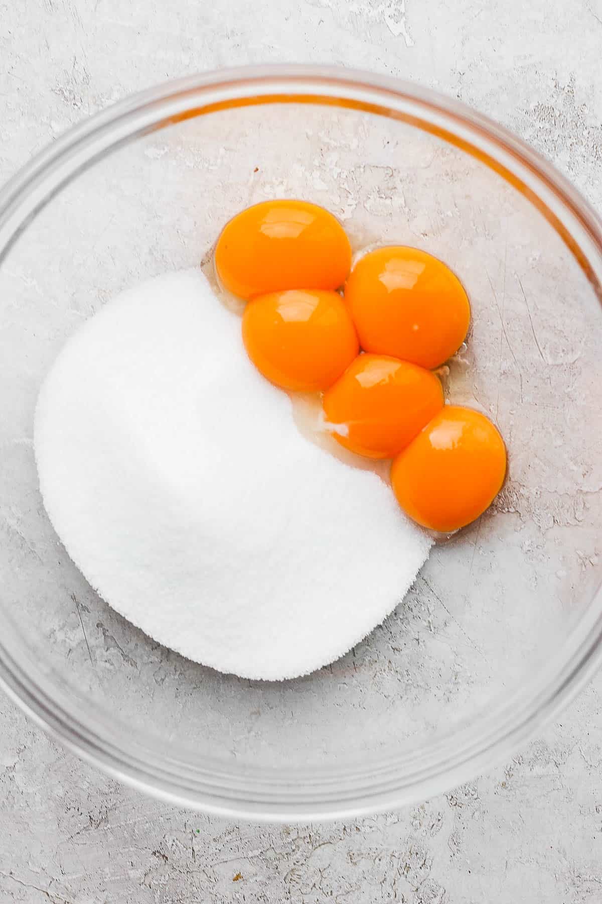 Egg yolks and sugar in a bowl.