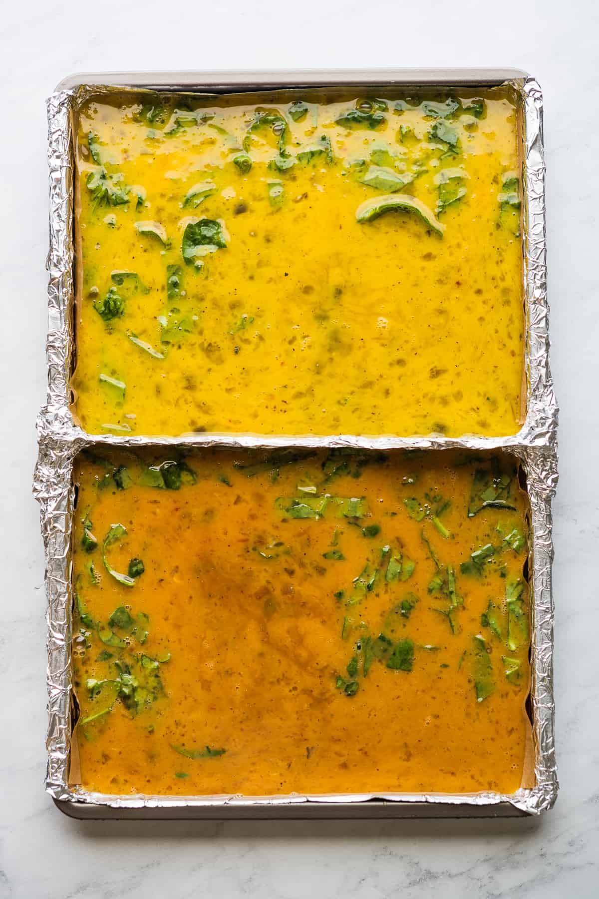 Whisked eggs on a sheet pan ready to bake.