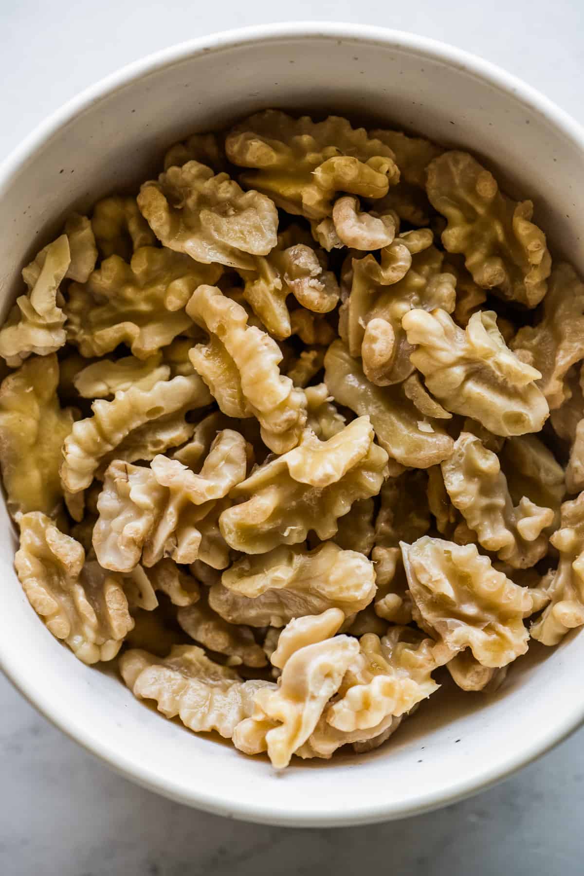 Shelled and skinned/peeled walnuts in a bowl.
