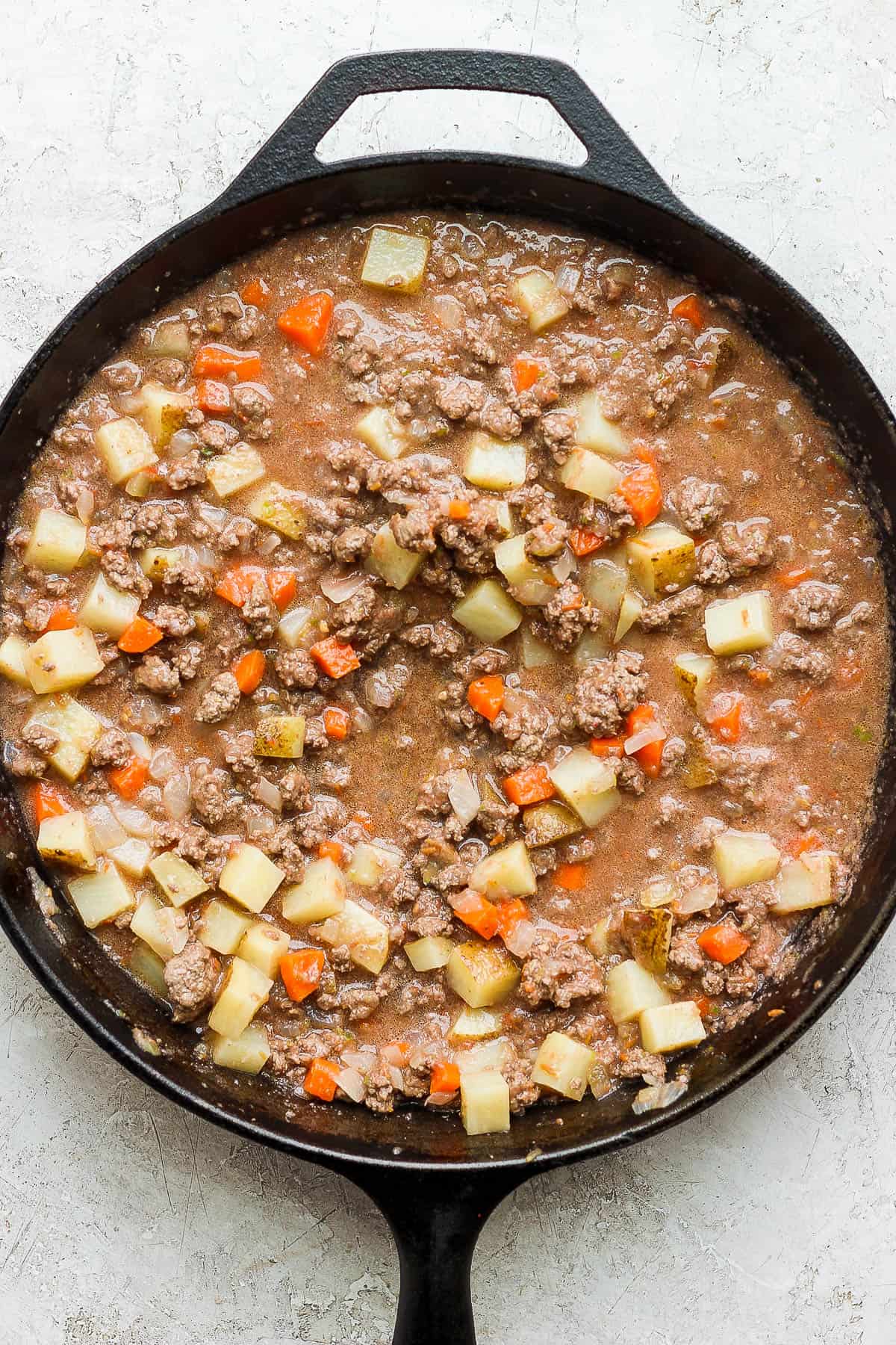 Picadillo cooking in a skillet.