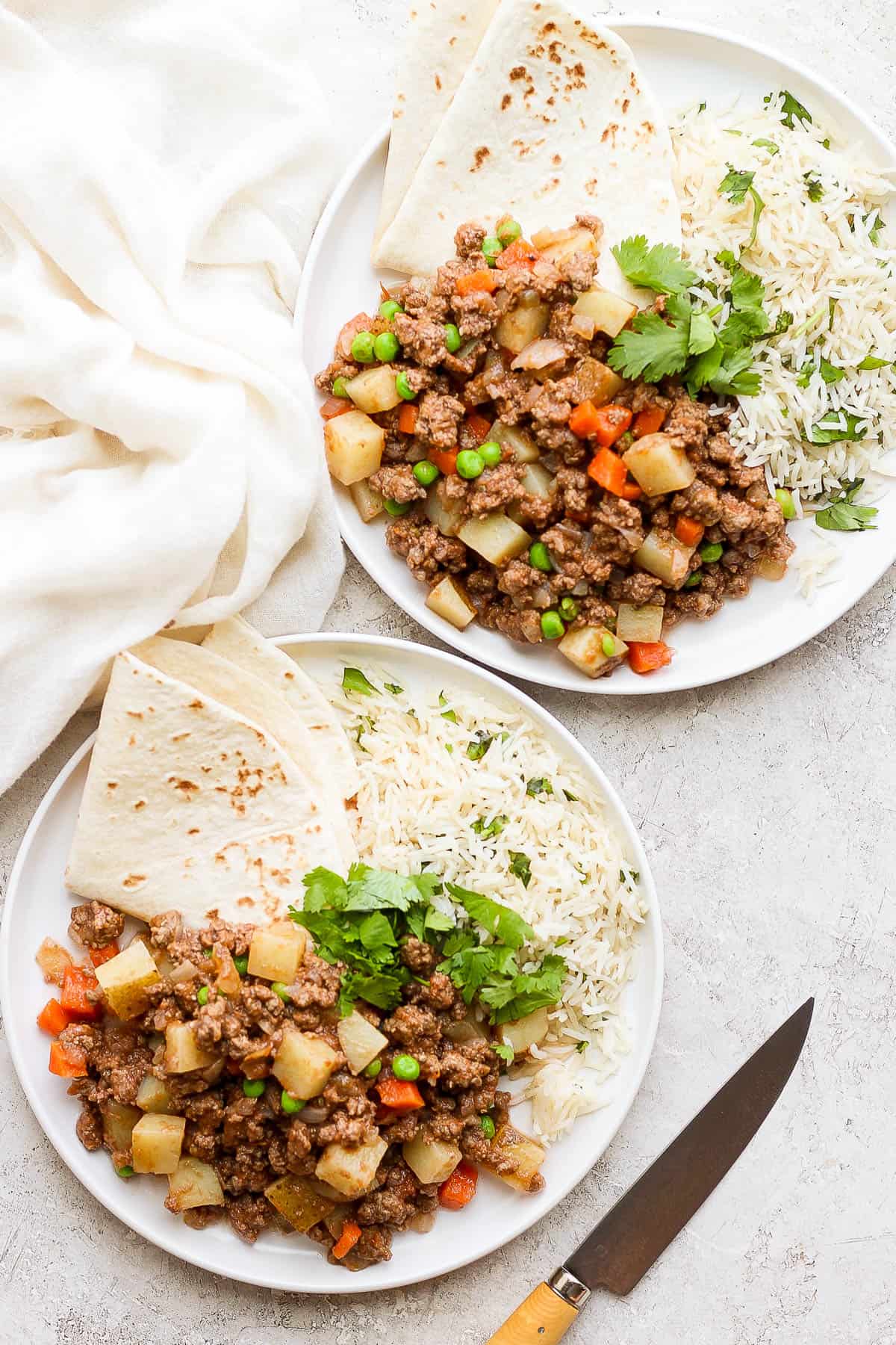 Picadillo on a plate served with rice and flour tortillas.