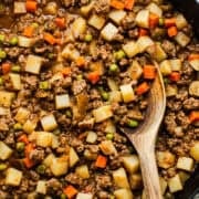Mexican picadillo recipe with ground beef, potatoes, and carrots in a skillet.
