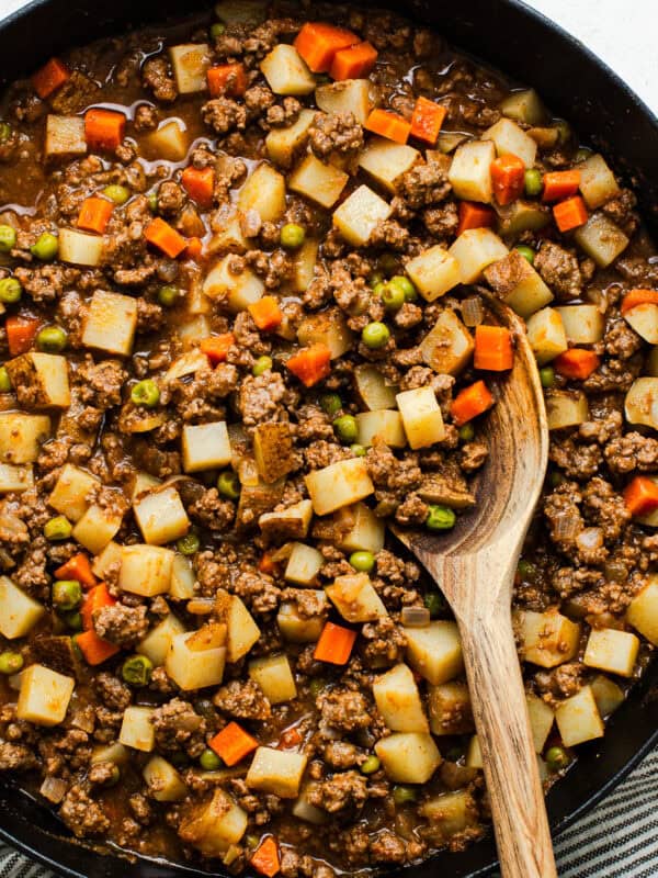 Mexican picadillo recipe with ground beef, potatoes, and carrots in a skillet.