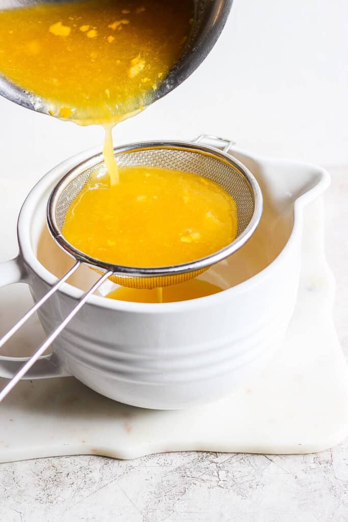 Mango syrup for raspados being poured through a strainer