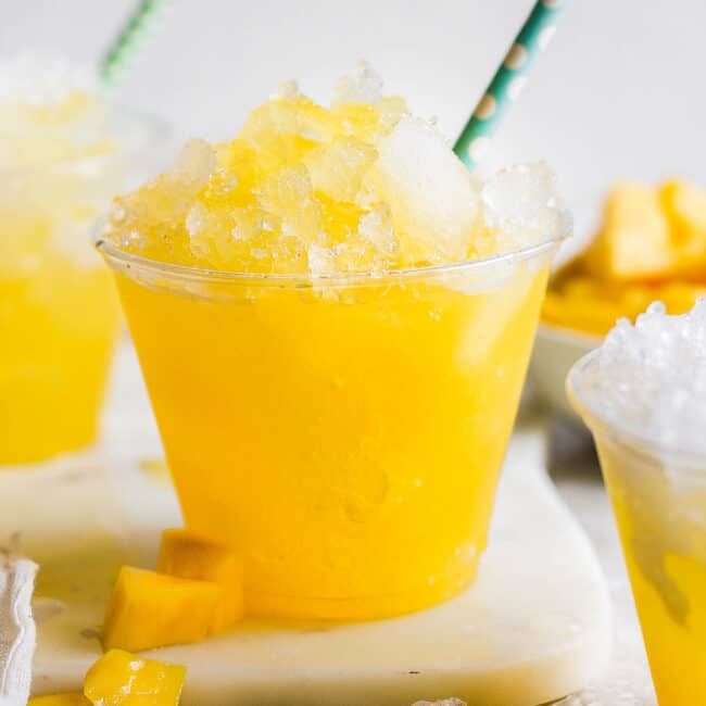 Raspados Mexicanos shaved ice in a cup with a straw made with a sweet mango syrup