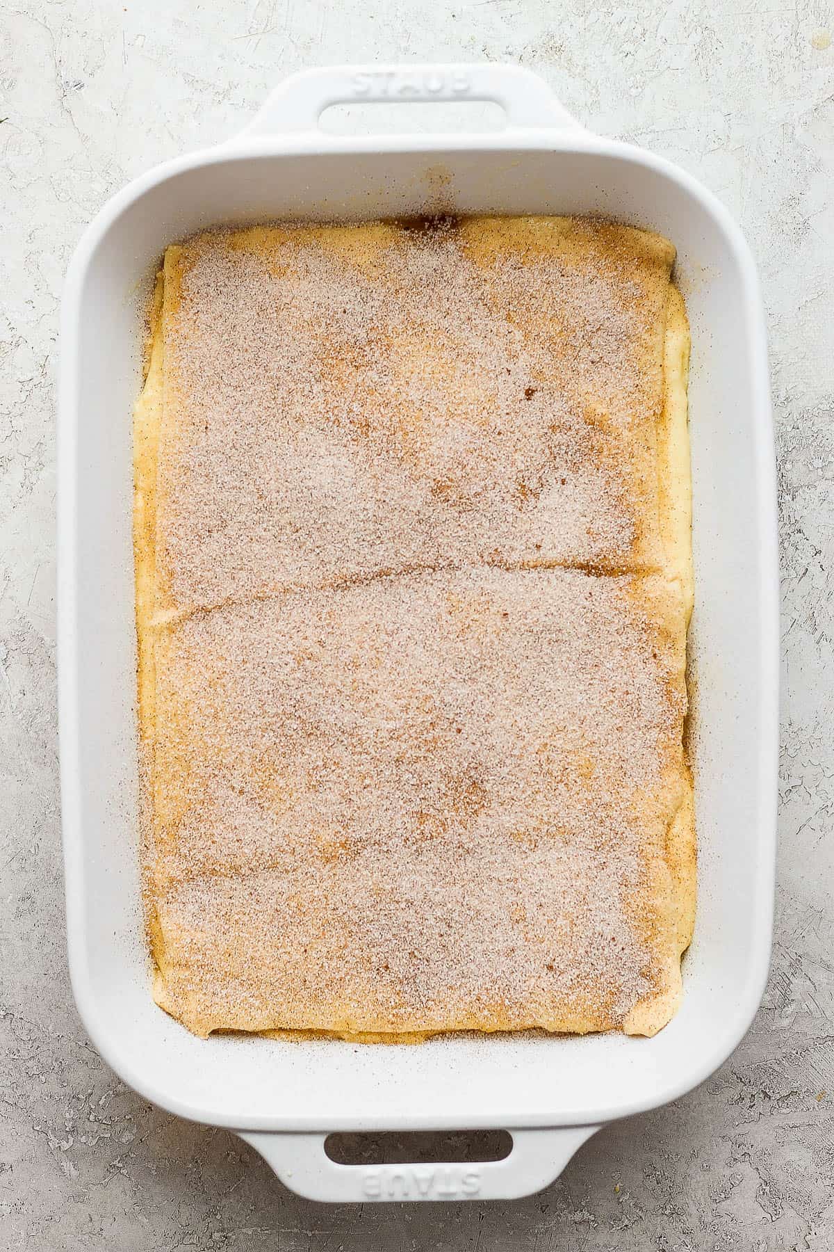 Cinnamon sugar sprinkled on top of crescent roll dough for sopapilla cheesecake.