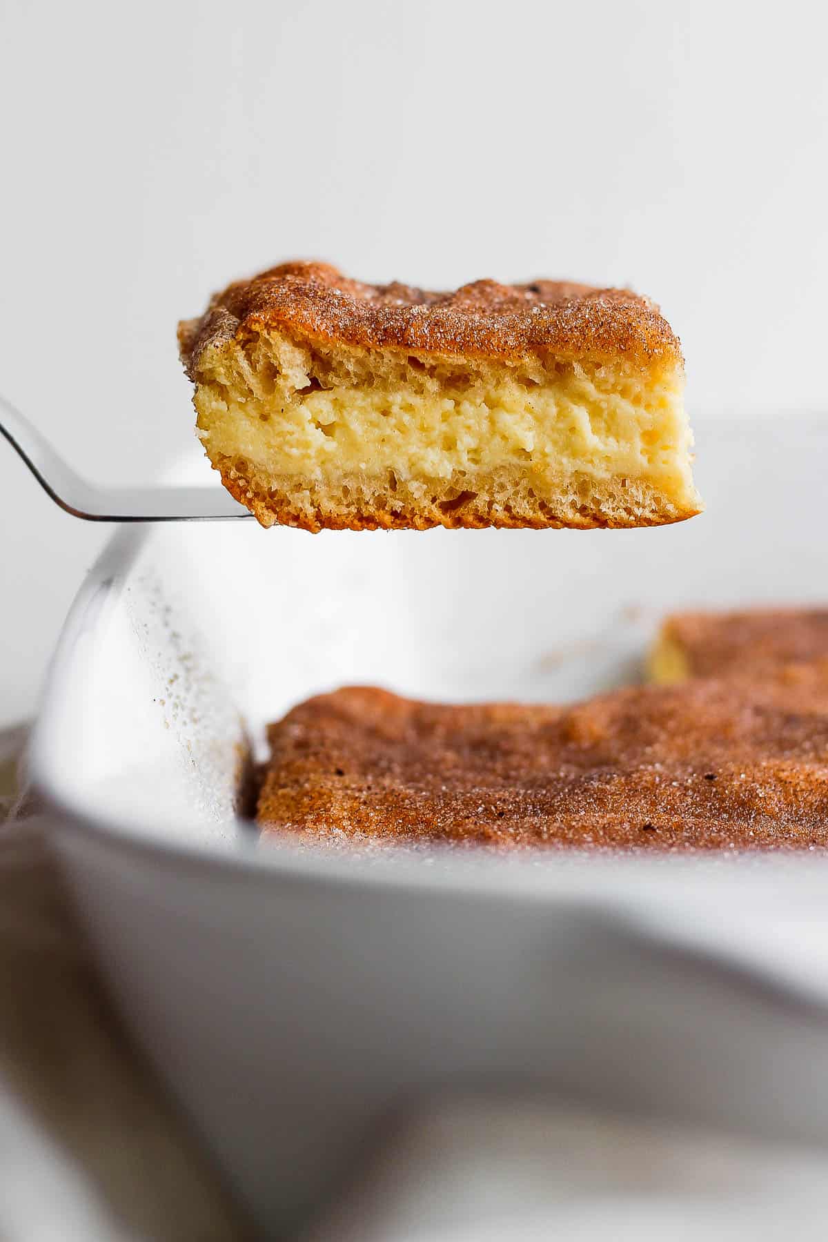 A slice of sopapilla cheesecake on a spatula.