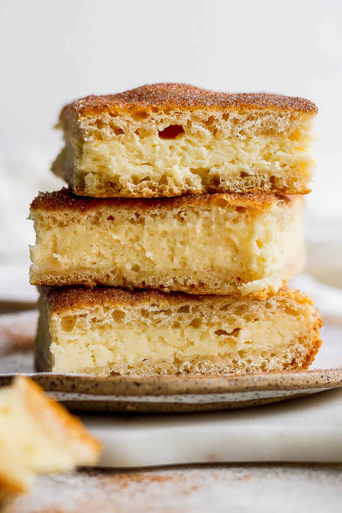 Sopapilla cheesecake sliced and stacked on top of one another.