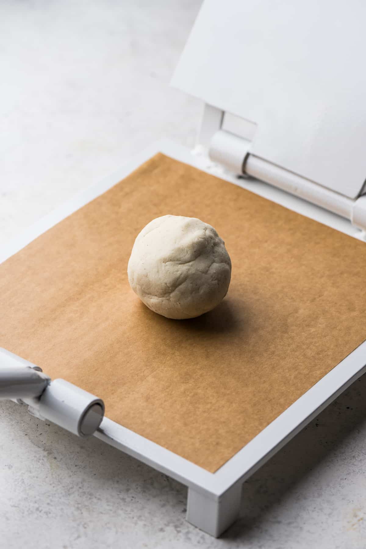 A masa dough ball on a tortilla press.
