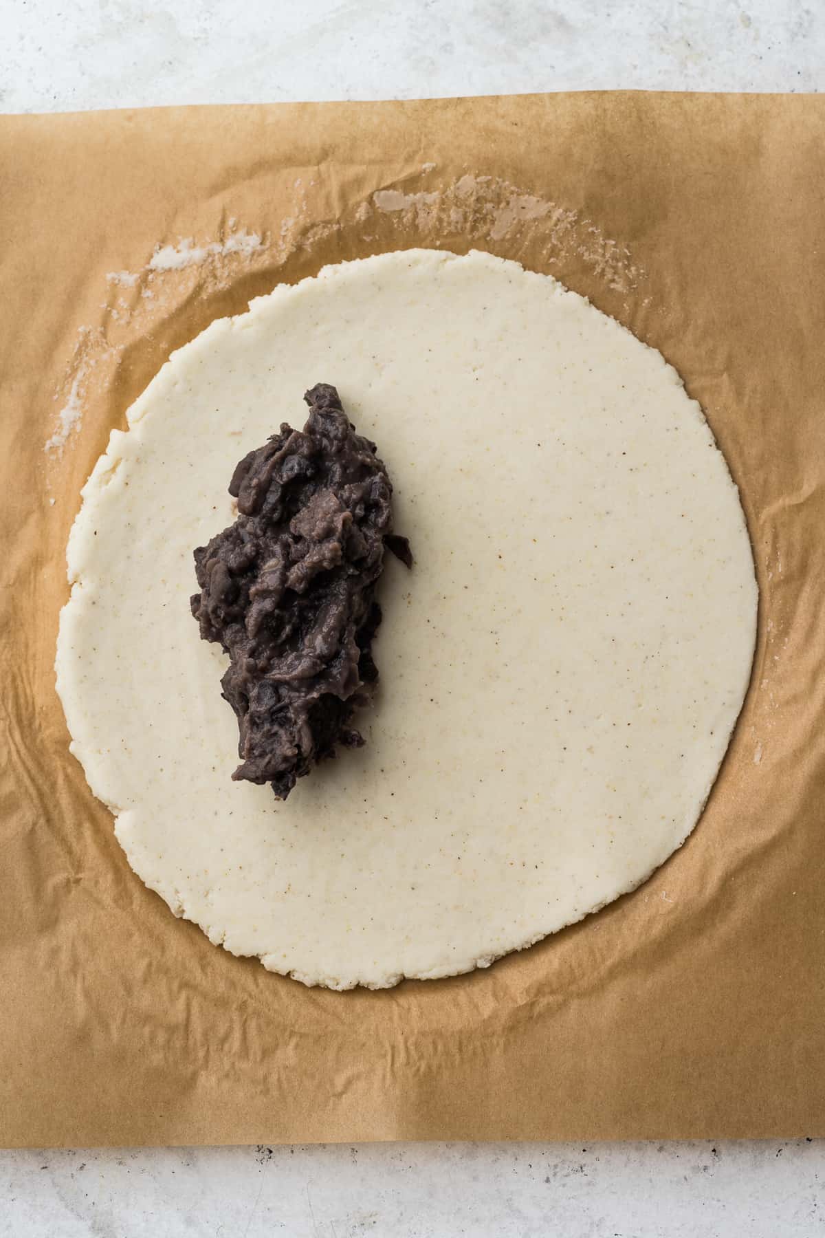 Refried beans on a circle of masa harina.