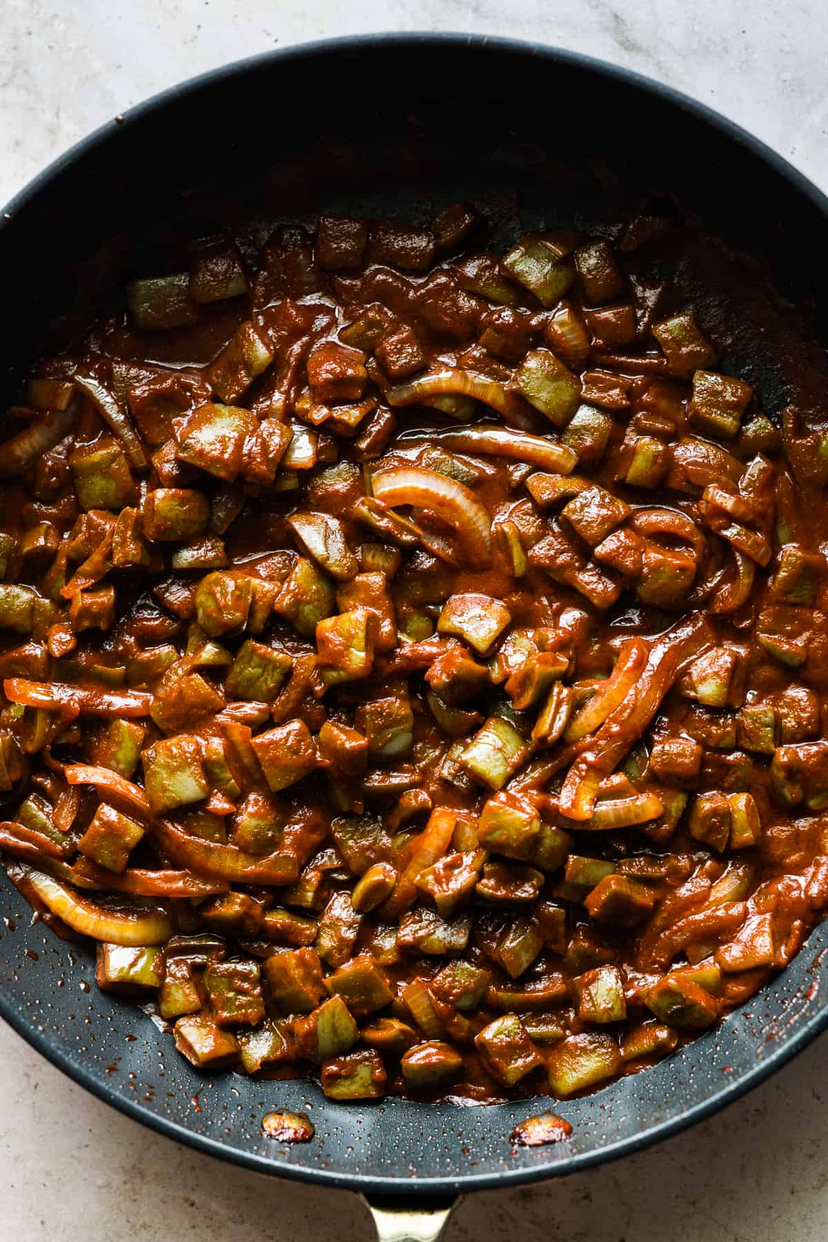 Cooked Mexican nopales en chile rojo in a large skillet.