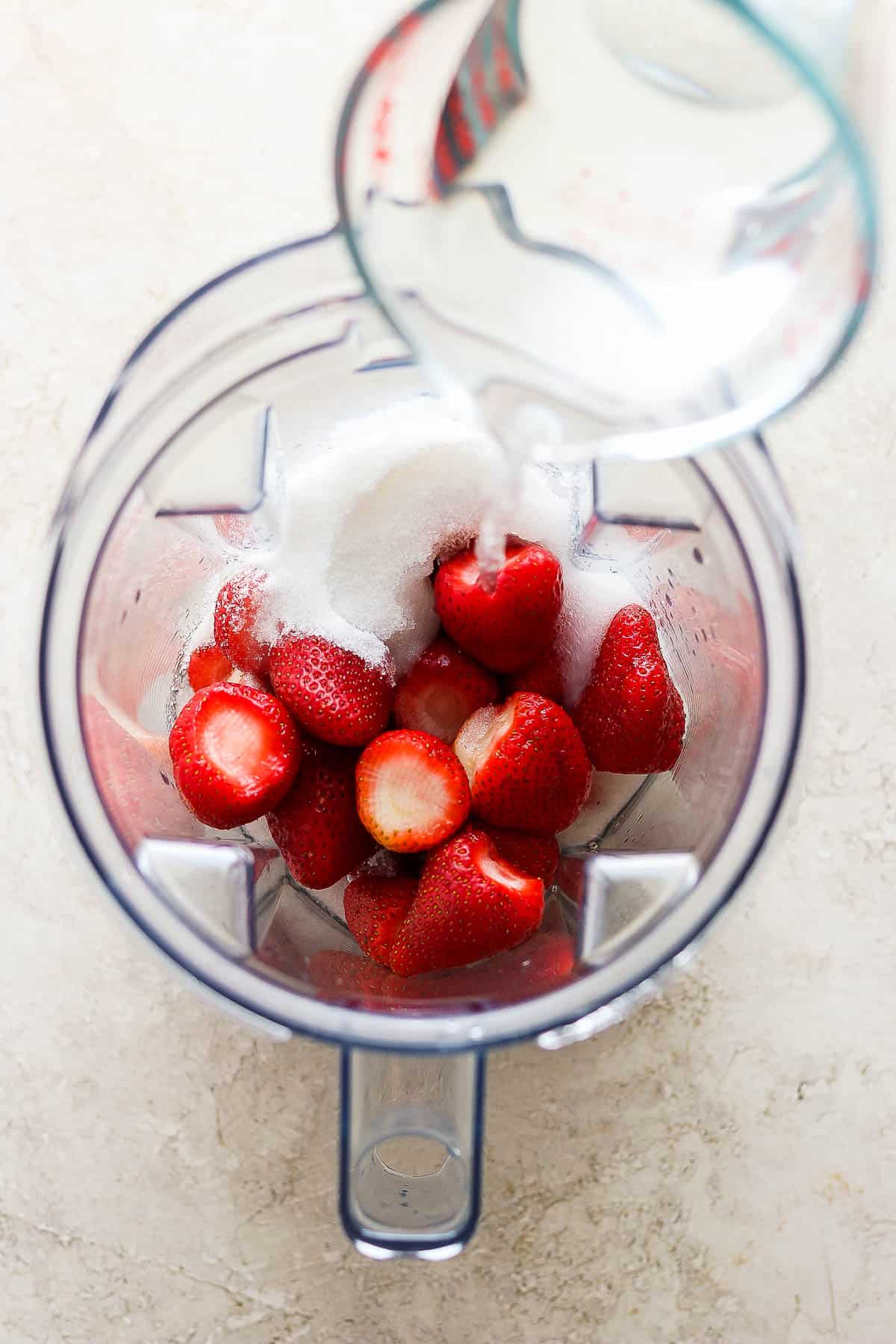 Strawberries, sugar, and water in a blender.