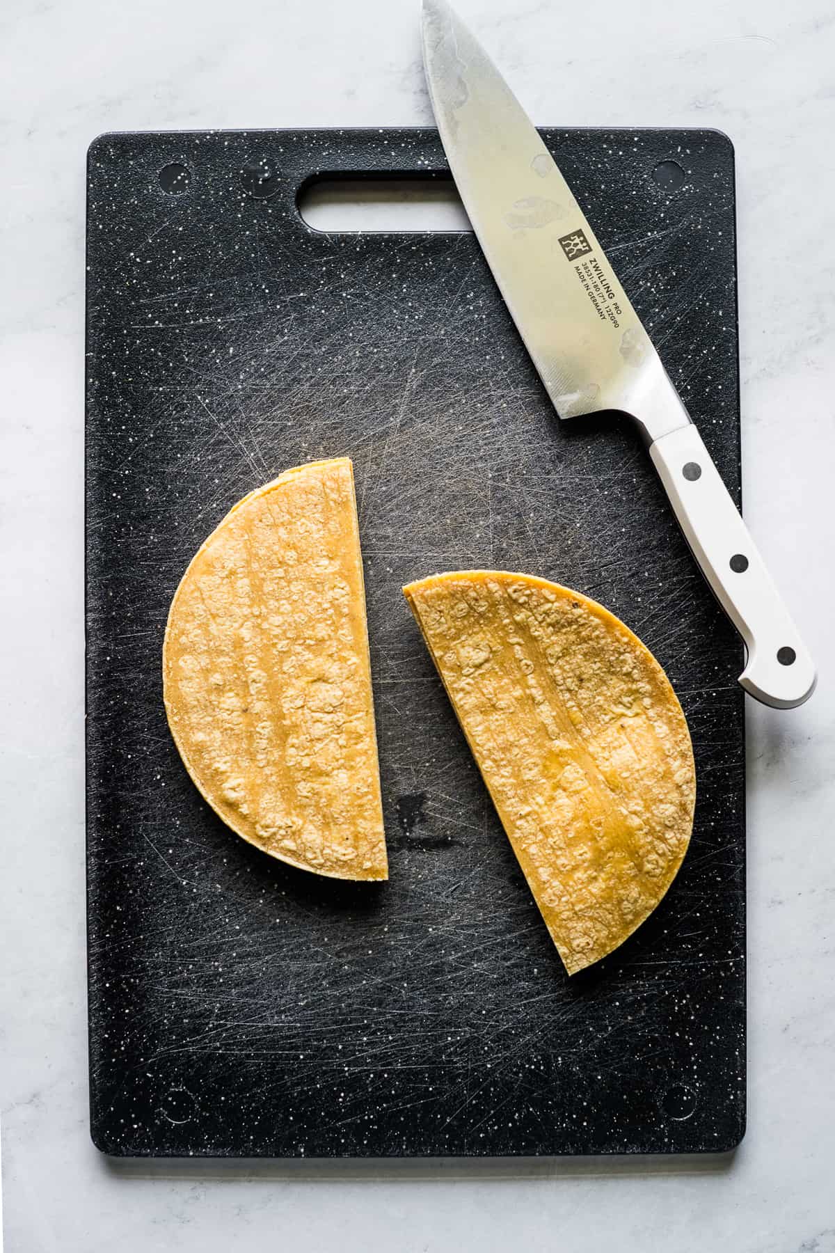 Corn tortillas cut in half down the middle.