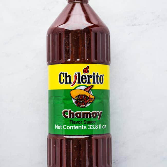 A bottle of chamoy on a table.