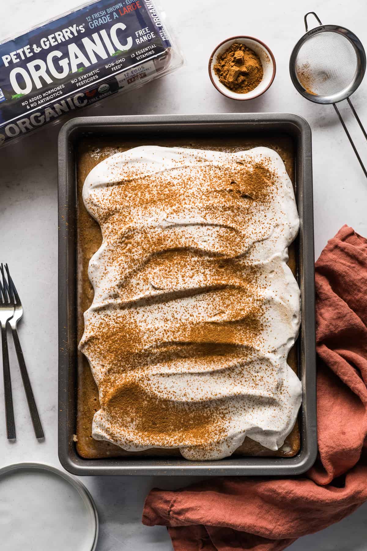 An apple tres leches cake topped with cinnamon whipped cream.