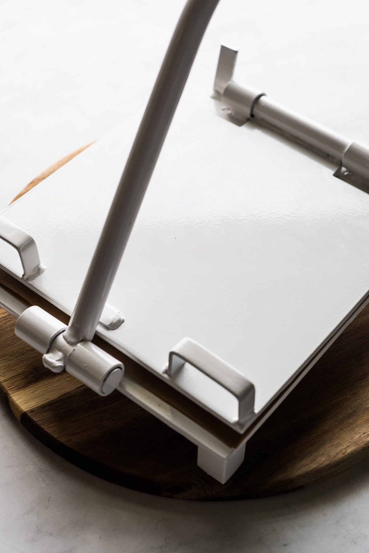 A white tortilla press on a table.