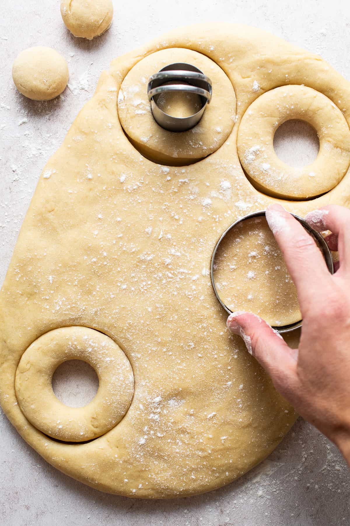 Mexican donuts (donas) being stamped out with a donut cutter.