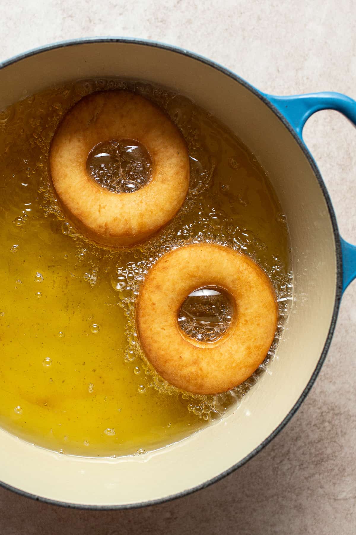 Mexican donuts being fried in hot oil.