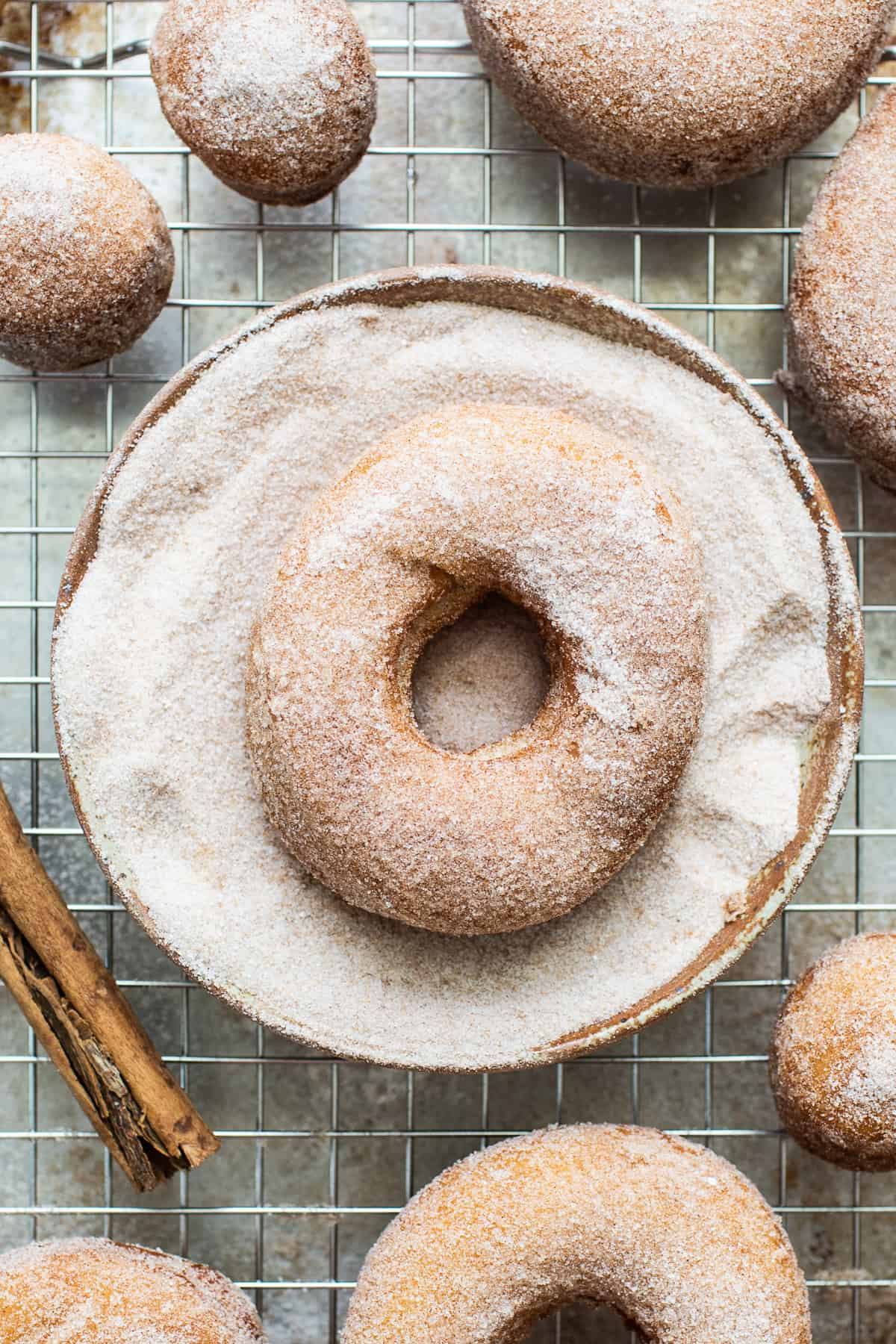 Mexican donuts being dipped in cinnamon sugar.