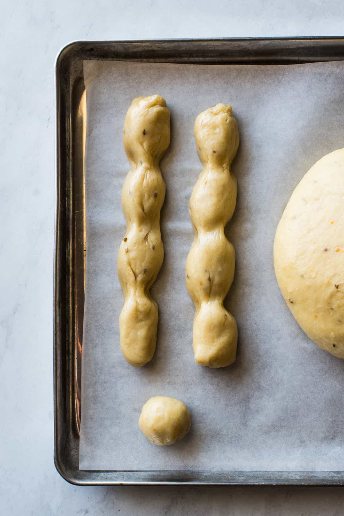 Rolled out dough and "bones" shaped for pan de muerto before being assembled.