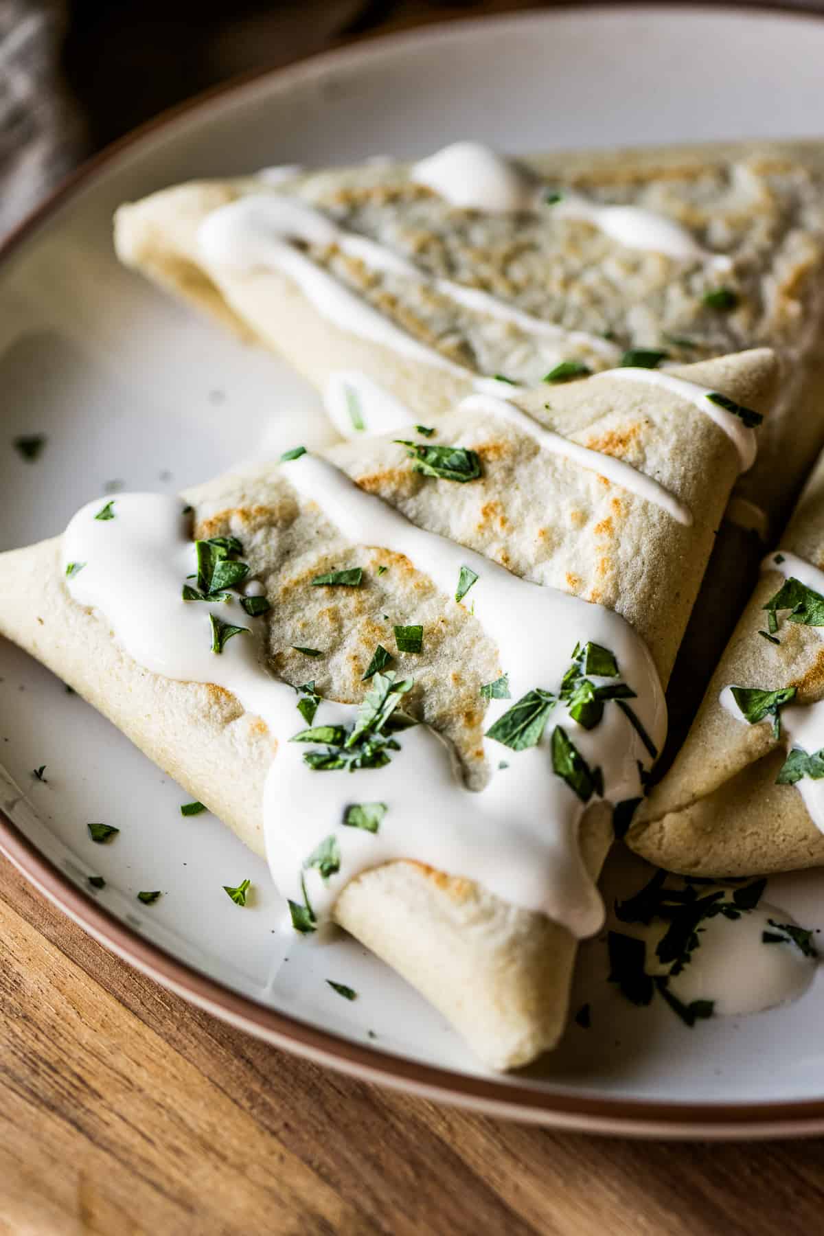 Tetelas on a plate garnished with Mexican crema and cilantro.