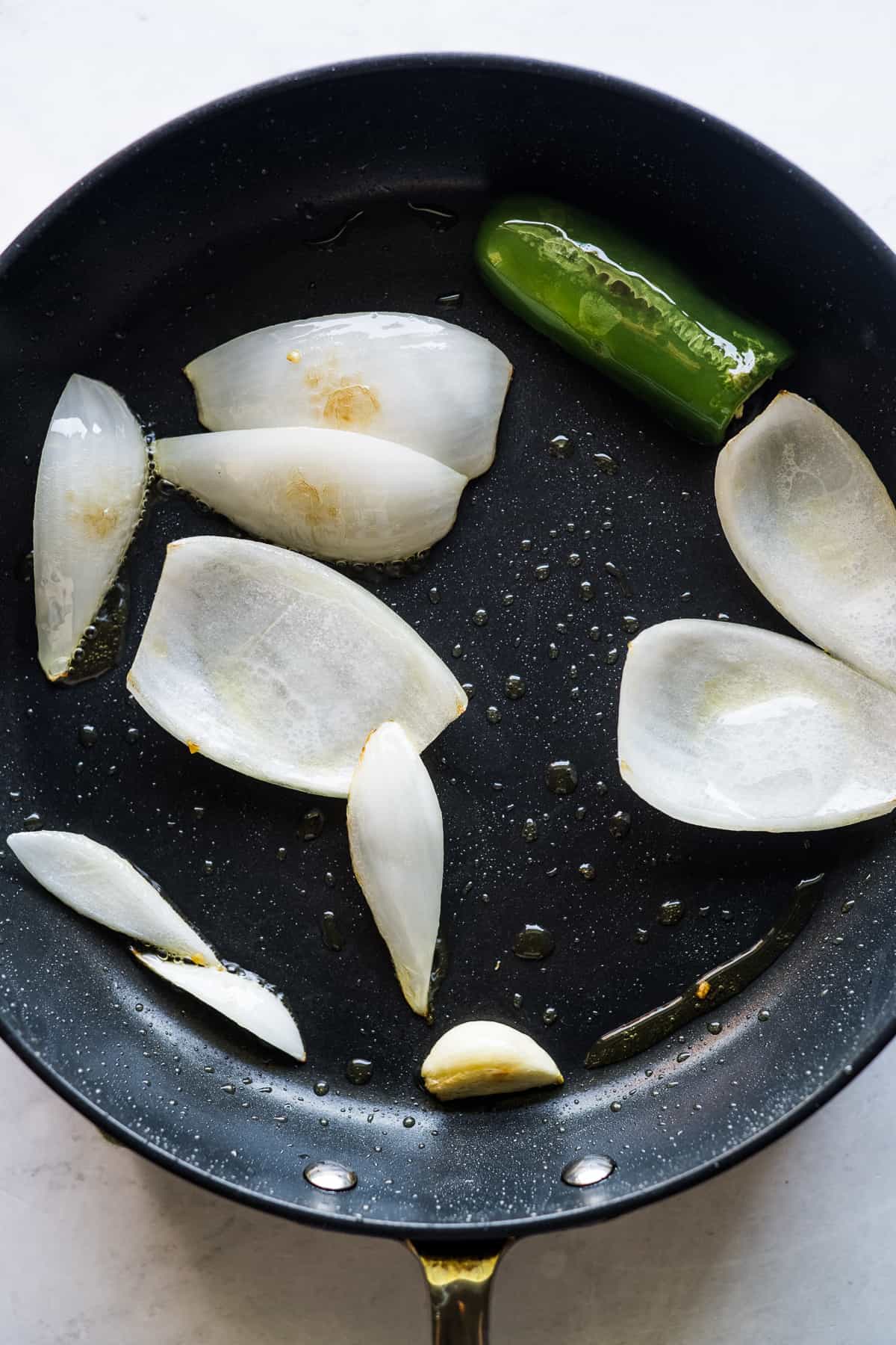 Onion, jalapeño, and garlic sauteing in a large skillet.