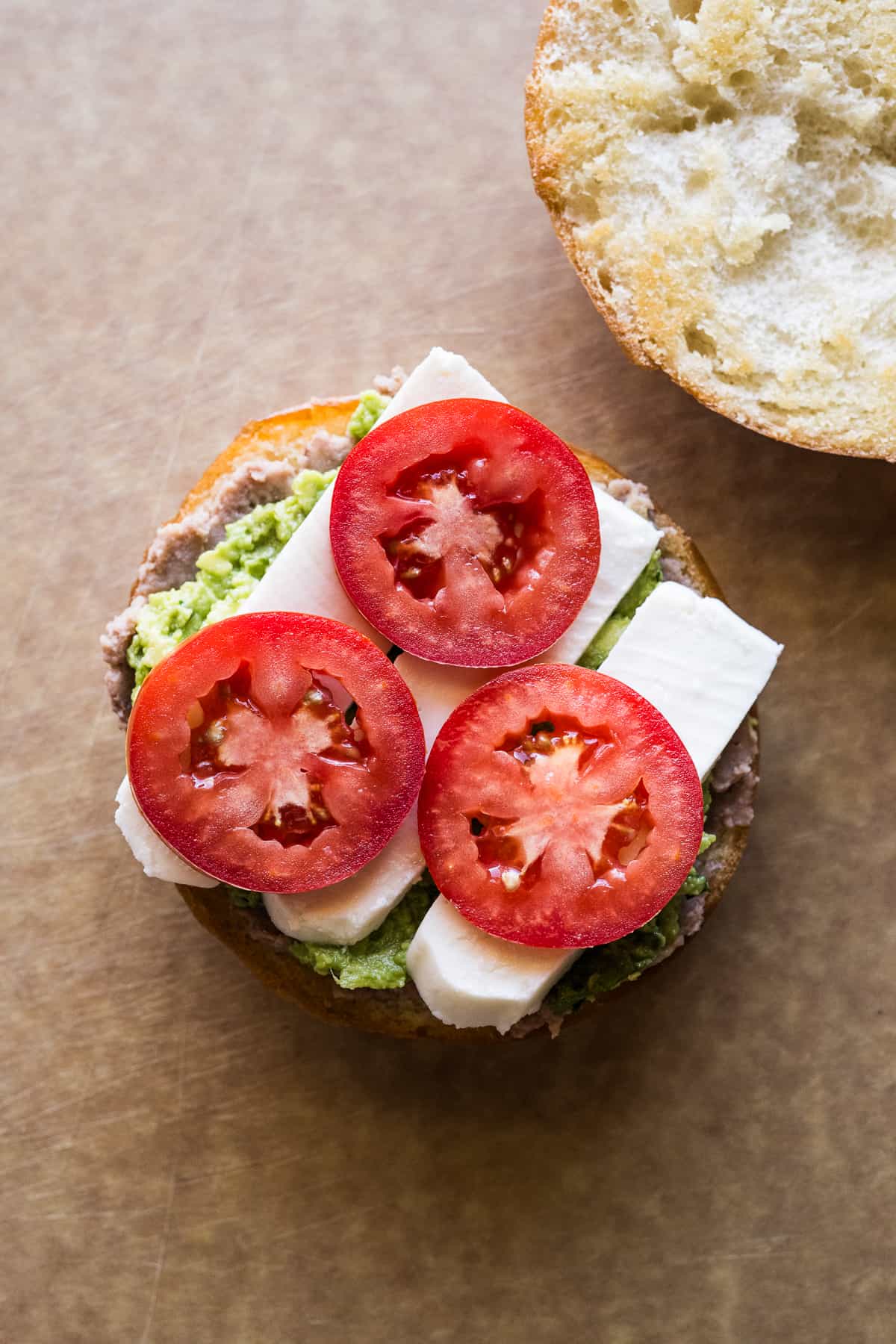 Tomatoes, queso fresco, refried beans and guacamole smeared on a telera roll.