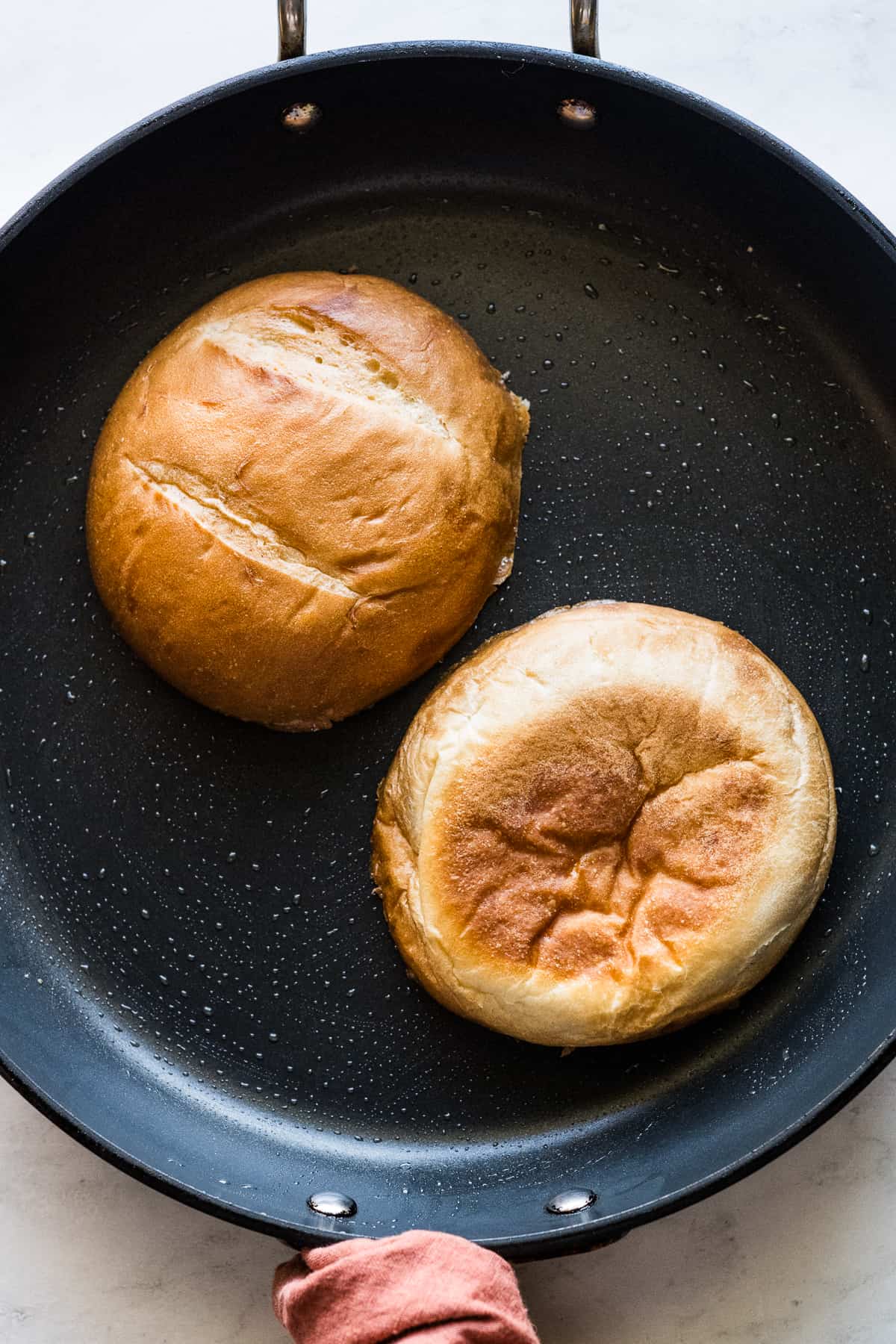 Telera bread toasting in a skillet with a little butter.