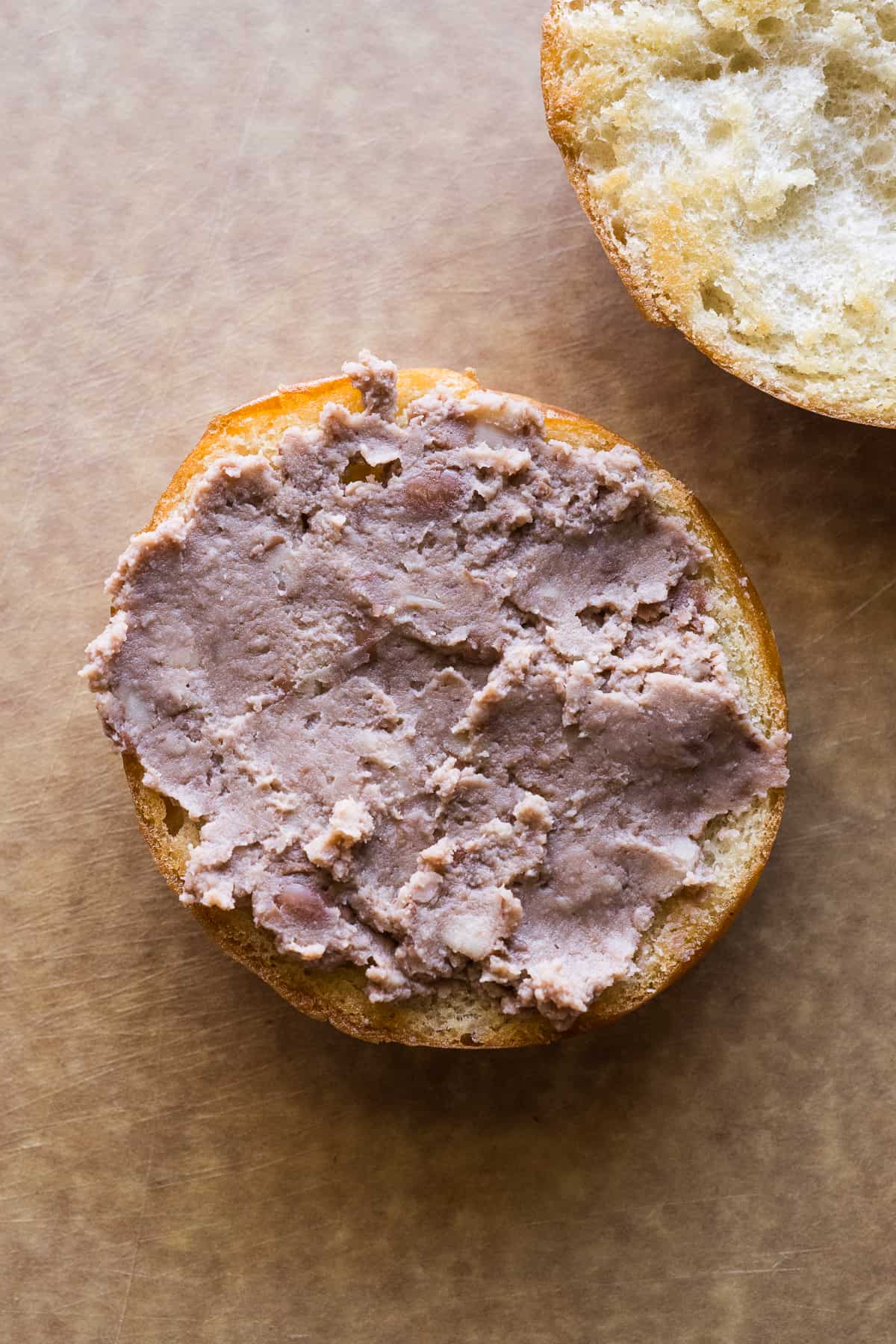 Refried beans smeared on a telera roll.