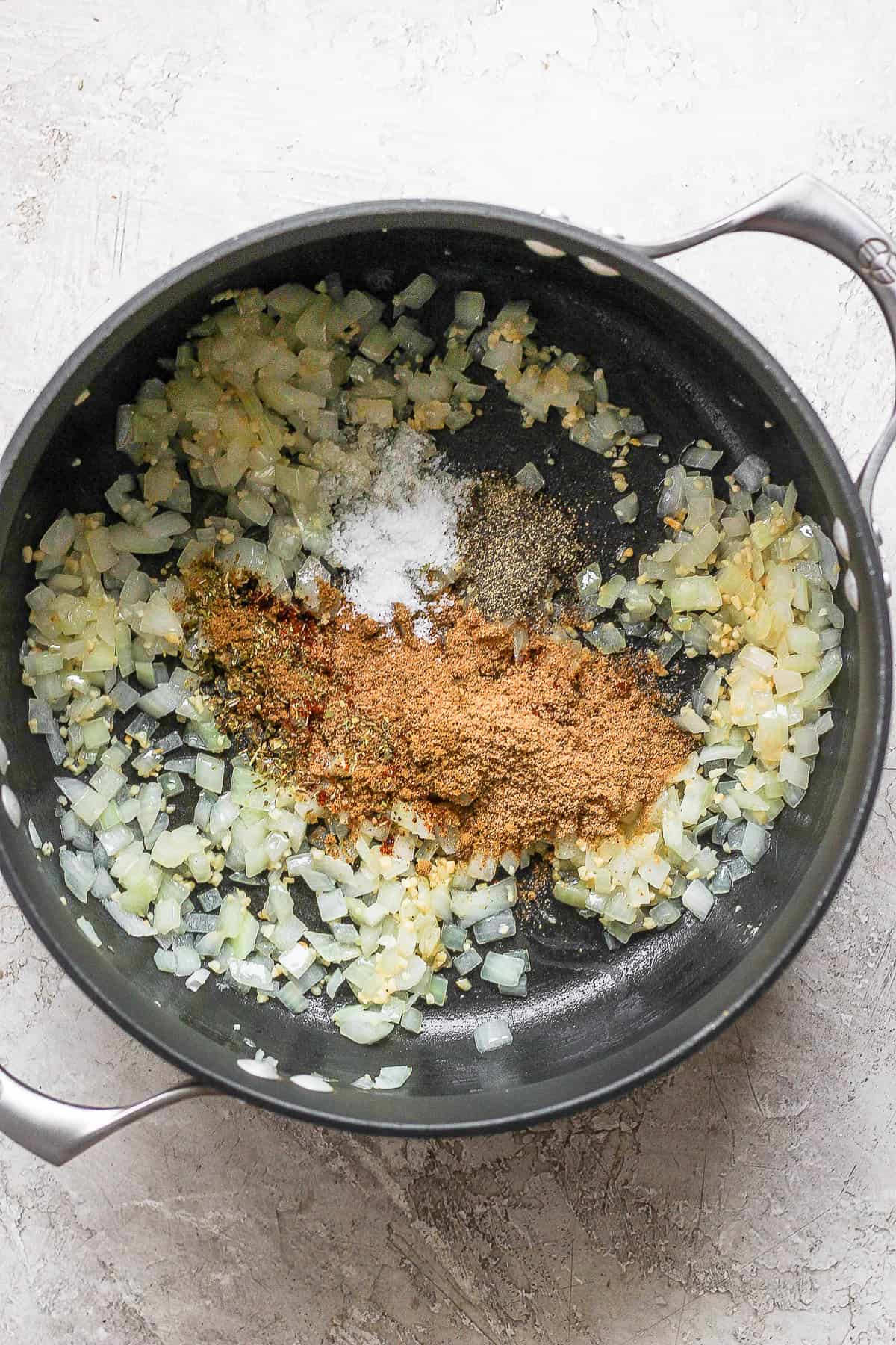 Onions, garlic, and seasonings cooking in a large pot.