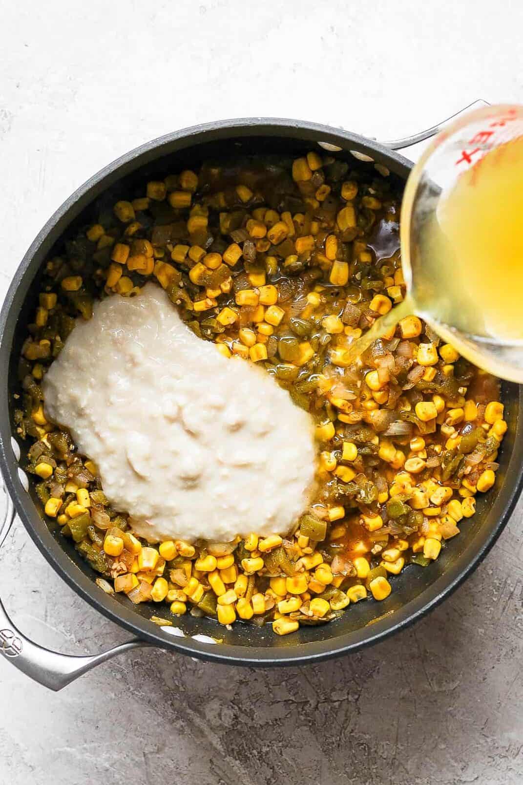 Blended beans and broth being poured into a pot to make white chicken chili.