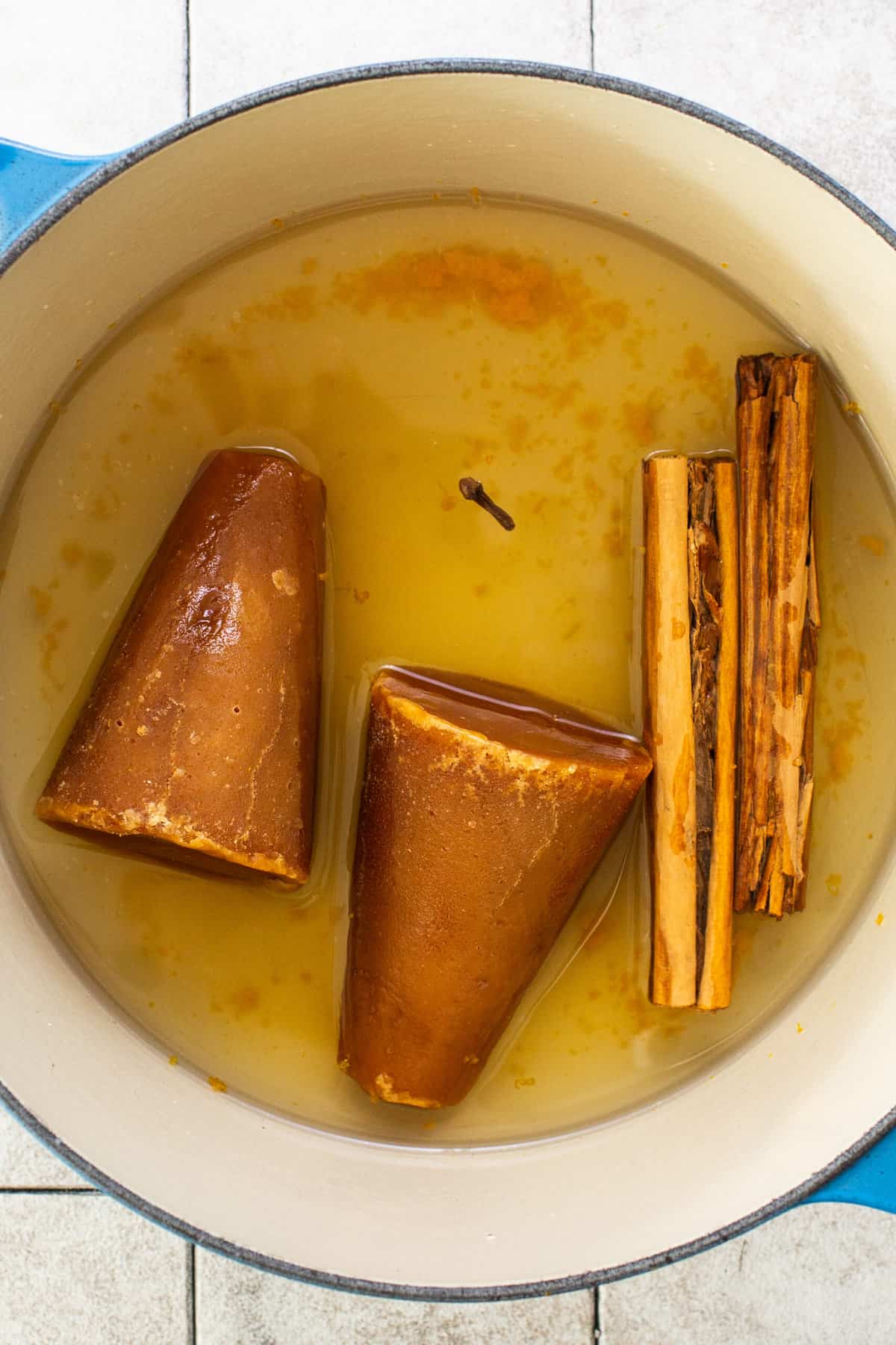 Piloncillo, clove, ceylon cinnamon, and orang zest in a pot.