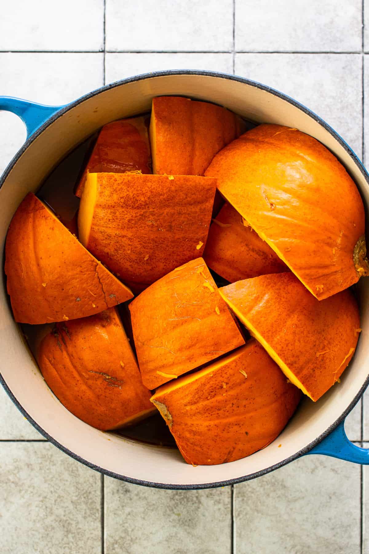 Cut pumpkin slices layer skin side up in a pot to make calabaza en tacha.