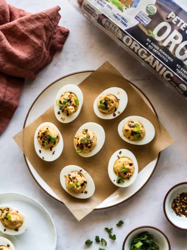Spicy deviled eggs garnished with green onions and crushed red pepper flakes.