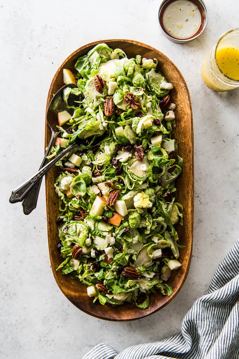 a brussels sprout salad in a wooden serving bowl