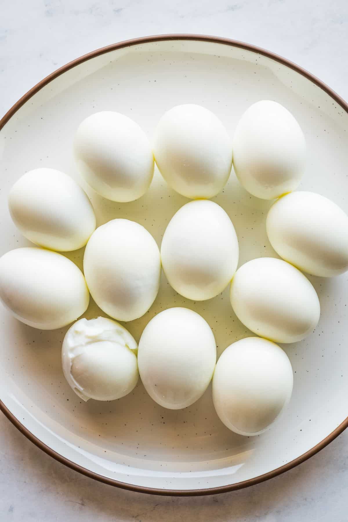 Peeled hard boiled eggs on a plate.