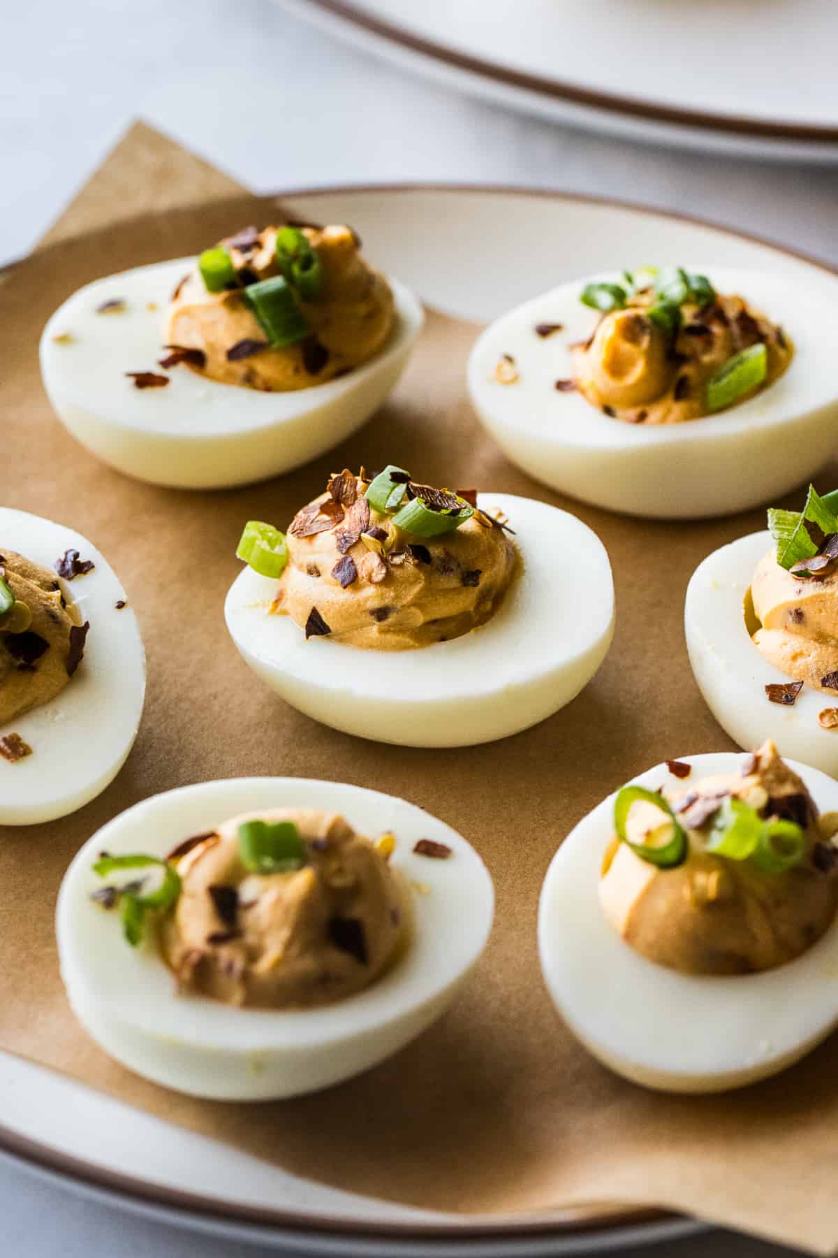 Spicy deviled eggs on a plate garnished and ready to be eaten.