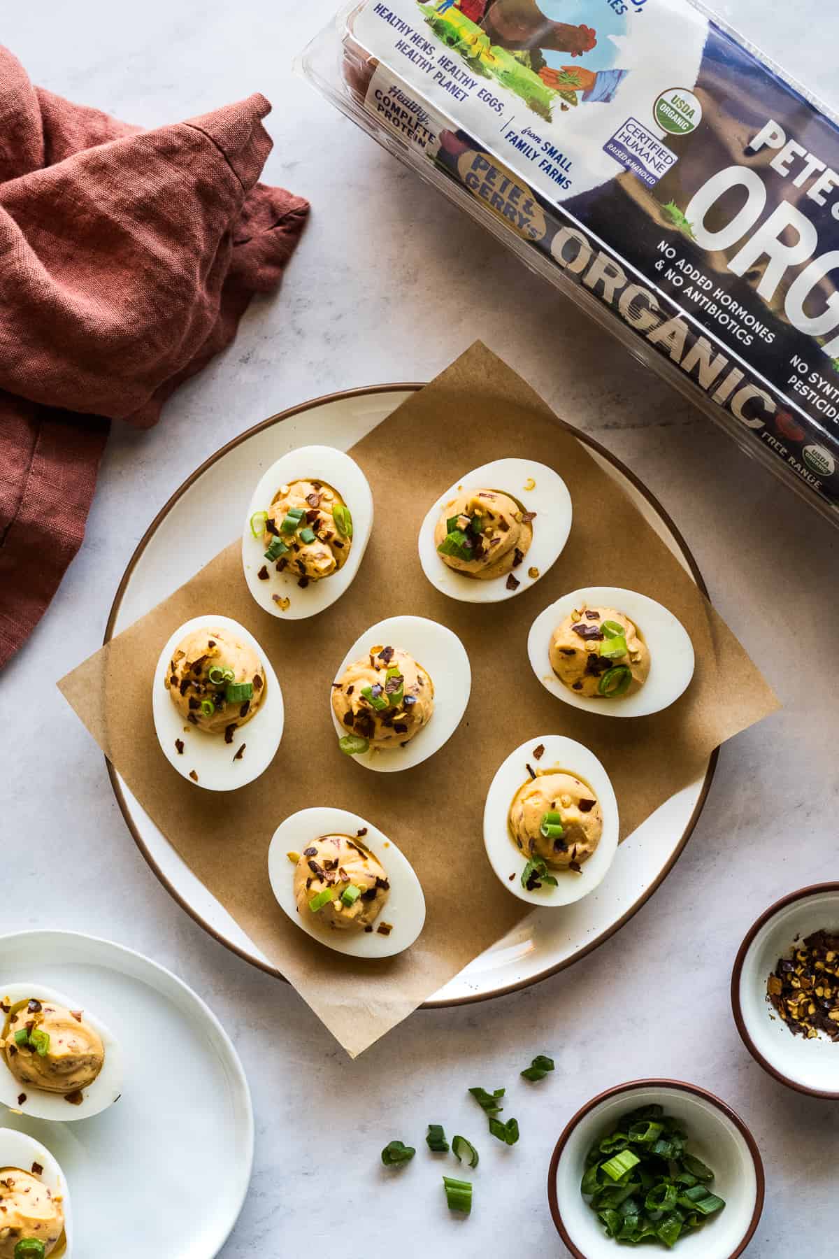 Spicy deviled eggs garnished with green onions and crushed red pepper flakes.