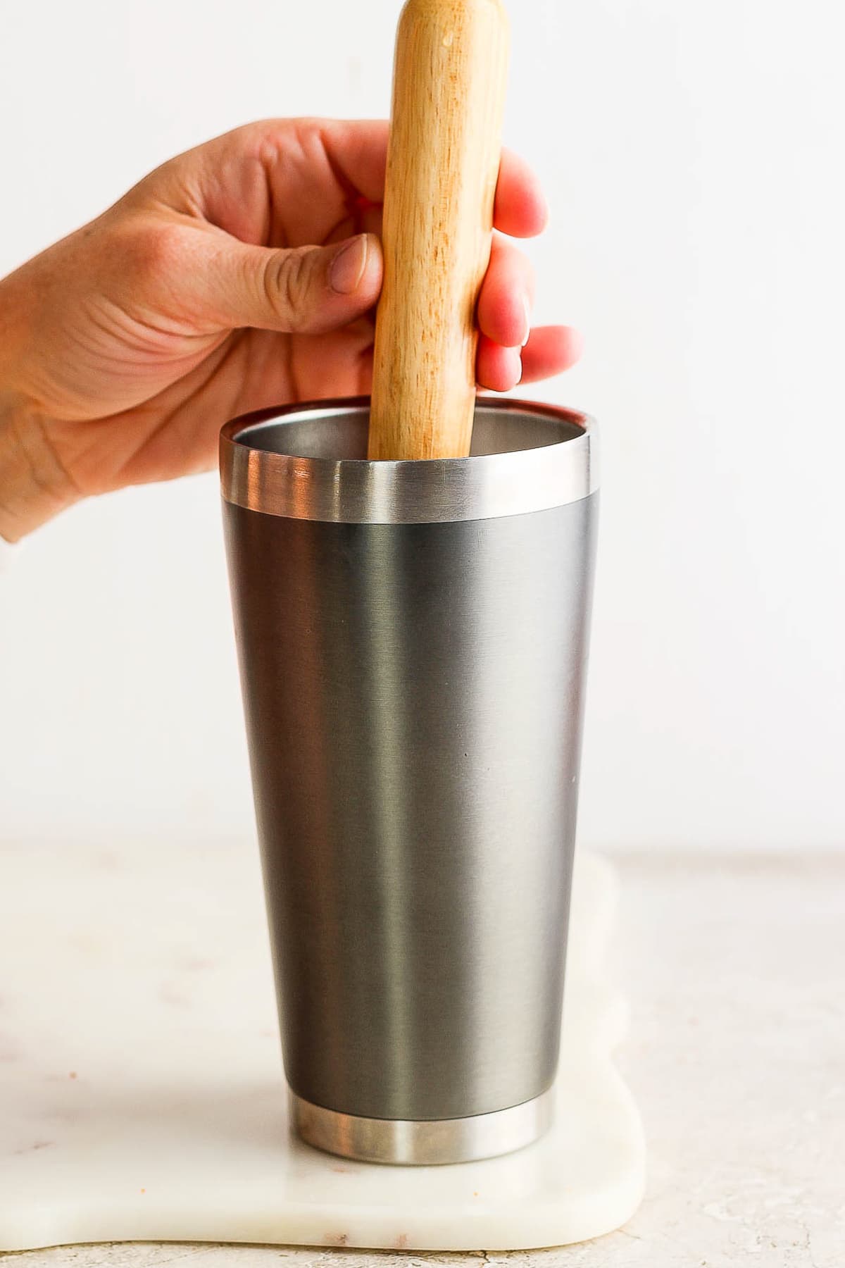 Muddling a jalapeño in a cocktail shaker