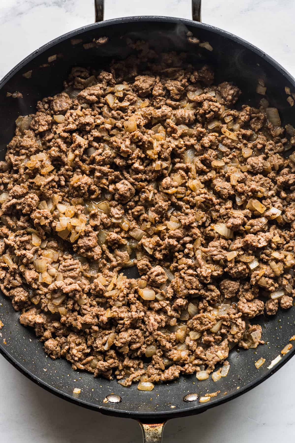 Cooked ground beef in a skillet.