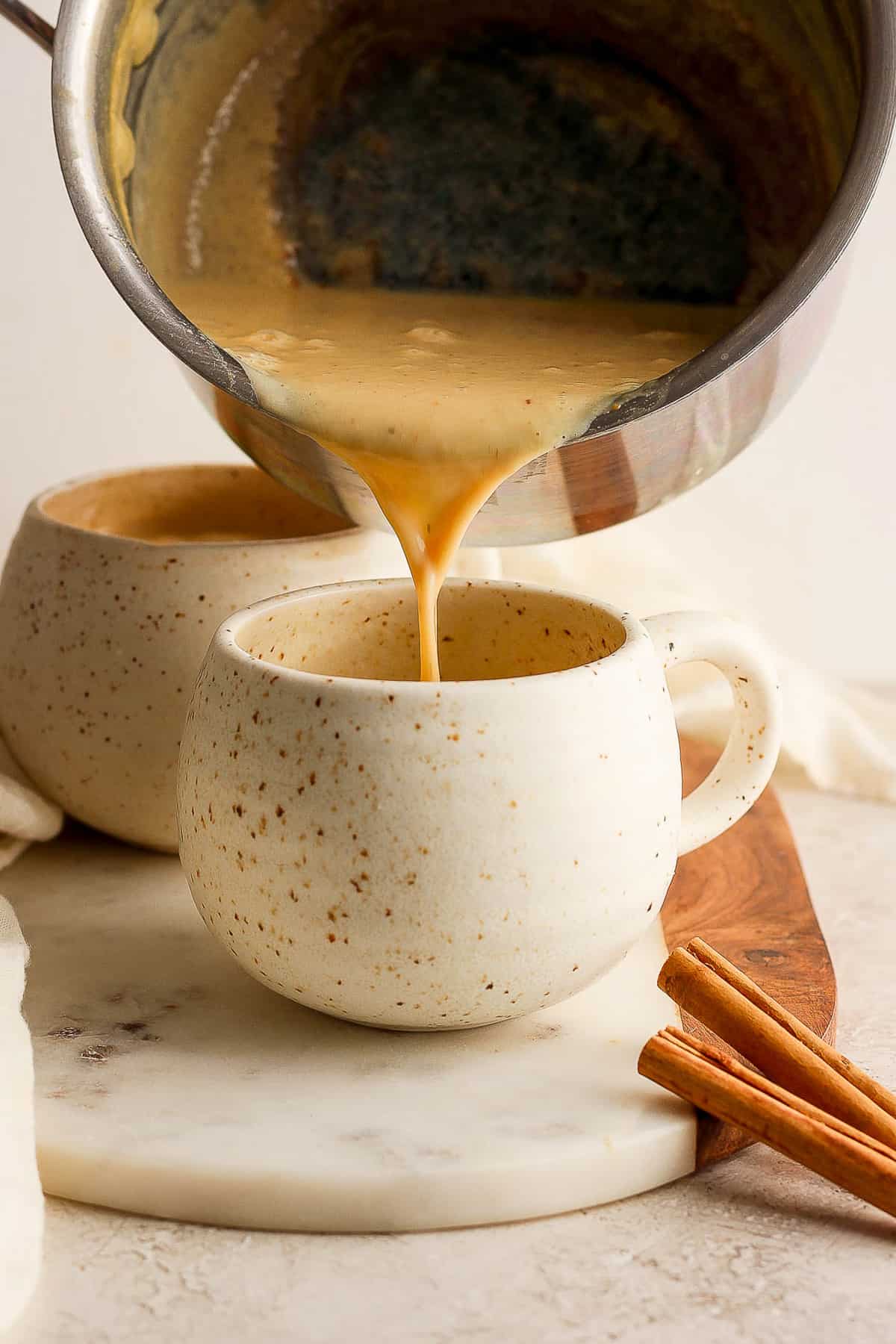 Atole de elote being poured into a cup.